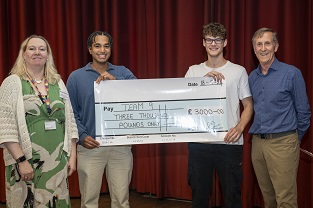 Associate V-C Annela Seddon, prizewinning students Aidan Meazzo and Archie Soares-Mullen, and Chair of Judging Aegis Professor John Thompson, at APUC Celebration Day 18 September 2024. Archie and Aidan hold a giant cheque for three thousand pounds.